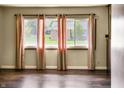 Bright living room featuring hardwood floors, large windows with curtains, and ample natural light at 1020 E Sixth St, Greenfield, IN 46140