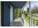 Open-air front porch with traditional railings, providing an unobstructed view of the charming blue home at 1130 W Congress Ave, Indianapolis, IN 46208
