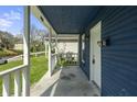 Inviting covered front porch with white railings, showcasing the entrance to a charming blue home at 1130 W Congress Ave, Indianapolis, IN 46208