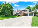 View of a two-story home with an attached two-car garage and a long concrete driveway at 11620 E 75Th St, Indianapolis, IN 46236