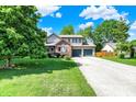 View of a two-story home with an attached two-car garage and a long concrete driveway at 11620 E 75Th St, Indianapolis, IN 46236