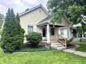 Inviting single-story home with a well-manicured lawn and lovely curb appeal at 1309 N Colorado Ave, Indianapolis, IN 46201