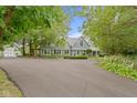 Charming gray two-story home with landscaped front yard and attached garage surrounded by mature trees at 14655 Little Eagle Creek Ave, Zionsville, IN 46077