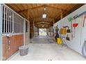Spacious horse stable featuring stalls, ample lighting, and concrete flooring at 14655 Little Eagle Creek Ave, Zionsville, IN 46077