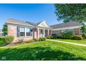 Lovely brick home showcasing a green lawn, blue shutters, and a striking red front door at 16156 Oliver St, Fishers, IN 46037