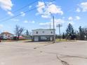 Two story commercial building with a gray and white exterior, garage doors and manicured landscaping at 1630 N Granville N Ave, Muncie, IN 47303