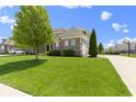 Attractive two-story house featuring manicured lawn, an attached garage, and a basketball hoop at 16305 Kenora N Ln, Fortville, IN 46040
