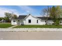 A quaint home featuring white siding, a dark roof, and a neatly maintained yard at 201 N 5Th St, Elwood, IN 46036