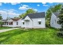 Attractive single-Gathering home with tidy lawn and classic white facade featuring awnings, accented by blue skies at 2015 S Hackley St, Muncie, IN 47302