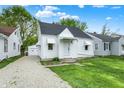 Quaint single-Gathering home with gravel driveway and white facade featuring awnings, complemented by lush green lawn at 2015 S Hackley St, Muncie, IN 47302
