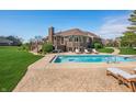 Expansive backyard with a pool, deck, mature trees, and view of the brick house at 2015 Saint Andrews Ct, Franklin, IN 46131