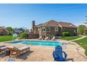 Beautiful backyard pool area with diving board, lounge chairs, and landscaped yard at 2015 Saint Andrews Ct, Franklin, IN 46131
