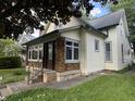 Quaint bungalow with vinyl siding, updated windows, and a well-maintained lawn at 2119 S Garfield Dr, Indianapolis, IN 46203