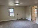 Cozy living room with neutral tones, new carpeting and window allowing natural light to flow through at 2271 Park Ave, Columbus, IN 47201