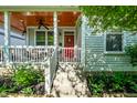 Inviting front porch with stained wood ceiling, white railings, and a charming red door at 2306 at 2306 Alabama St, Indianapolis, IN 46205