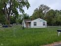 Traditional one-story home with a fenced yard, mature trees, and a classic mailbox at 2315 E 3Rd St, Anderson, IN 46012