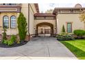 Beautiful home with an arched gate leading to a driveway and a meticulously kept lawn at 2377 Finchley Rd, Carmel, IN 46032