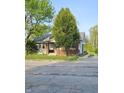 One-story home with brick accents, small front porch, and side driveway with a glimpse of the backyard at 3547 N Emerson Ave, Indianapolis, IN 46218