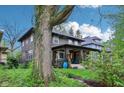 View of home with beautiful yard, lush landscaping, and a large tree, creating a serene setting at 4169 Central Ave, Indianapolis, IN 46205