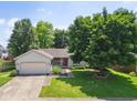 Charming single-story home featuring a well-maintained lawn, attached garage, and mature shade tree at 4611 29Th St, Columbus, IN 47203