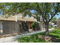 Charming exterior view with well-kept lawn, mature tree, and privacy fence with a pedestrian access gate at 5177 Fairway Dr, Avon, IN 46123
