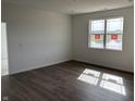 Bedroom featuring a large window providing ample natural light, fresh white paint, and modern wood-look flooring at 5204 Cartland Dr, Indianapolis, IN 46239