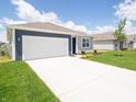 Side view of a well-manicured single-story home with a blue and gray exterior, white garage door and green lawn at 5204 Cartland Dr, Indianapolis, IN 46239