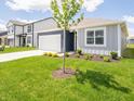 Inviting single-story home with blue and gray siding and a lush green lawn, providing excellent curb appeal at 5204 Cartland Dr, Indianapolis, IN 46239