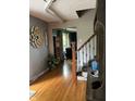 Bright foyer with hardwood floors, decorative accents, and a view into the living room at 5282 W Blue Bell Dr, New Palestine, IN 46163