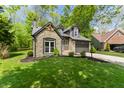 Beautiful home with a stone facade, gray siding, and a lush green lawn at 5548 Painted Maple Ct, Indianapolis, IN 46254