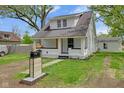 Charming renovated home with a vibrant yellow front door, landscaping, and a well-maintained lawn at 555 S Auburn St, Indianapolis, IN 46241
