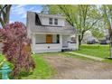 Charming renovated home with a vibrant yellow front door, landscaping, and a well-maintained lawn at 555 S Auburn St, Indianapolis, IN 46241
