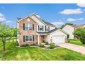 Traditional two-story home featuring a well-maintained lawn, brick accents, vinyl siding, and an attached garage at 5617 Gainesway Dr, Greenwood, IN 46142