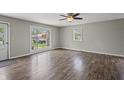 Bright living room features laminate flooring, ceiling fan, and large picture window providing plenty of natural light at 6231 W Clinton St, Stilesville, IN 46180