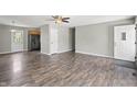 Spacious living room with wood-look flooring and ceiling fan open to the kitchen in this well lit open floorplan at 6231 W Clinton St, Stilesville, IN 46180