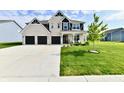 Spacious white brick home featuring a three-car garage, lush green lawn, and modern architectural details at 6398 Marden Trl, Brownsburg, IN 46112