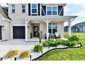 Charming front porch with seating, decorative plants, and a welcoming entrance to a beautifully landscaped home at 6398 Marden Trl, Brownsburg, IN 46112