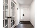 Clean, bright foyer with gray wood flooring, a decorative front door, and glass french doors at 6559 Ambrosia Ln, Pendleton, IN 46064