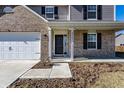 Front porch and door with brick and gray siding and trimmed front garden at 6559 Ambrosia Ln, Pendleton, IN 46064