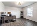 Bright, spacious home office with gray wood flooring, ample natural light, and a modern desk at 6559 Ambrosia Ln, Pendleton, IN 46064