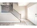 Bright entryway features wood-look flooring, a staircase with wood railings, and a white front door at 657 Kilmore Dr, Pendleton, IN 46064