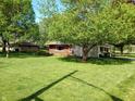 Expansive, well-maintained lawn showcases this brick ranch home with covered carport and mature shade trees at 7017 Mc Lain Dr, Indianapolis, IN 46217