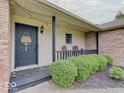 Inviting front porch with black railing, string lights, and decorated front door at 710 Marie Ln, Fortville, IN 46040