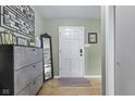 Entryway featuring modern decor, light green walls, a white door, and wood-look flooring at 7153 N Audubon Rd, Indianapolis, IN 46250