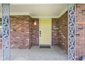 Covered front porch features decorative metal supports, a brick facade, and a bright yellow front door at 7153 N Audubon Rd, Indianapolis, IN 46250