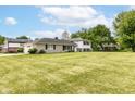 Charming two-story home with light brick and black shutters, situated on an expansive lawn at 7250 Hoover Rd, Indianapolis, IN 46260