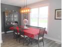 Cozy dining room featuring a stylish light fixture, table and seating with an accent wall at 7897 Hickory Ridge Ln, Mooresville, IN 46158