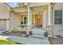 Close up of a charming front porch with stone columns and meticulous landscaping at 7897 Hickory Ridge Ln, Mooresville, IN 46158