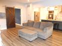 Modern living room features a comfortable couch, sliding barn door, and an open view into the kitchen at 7897 Hickory Ridge Ln, Mooresville, IN 46158