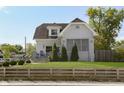 Attractive home showcasing manicured lawn, inviting porch and wood fence for added curb appeal at 825 Iowa St, Indianapolis, IN 46203